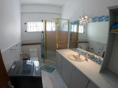 a bathroom with a sink and a shower and a toilet at Spacious Apartment with Pool in Blue Bay in Blue Bay