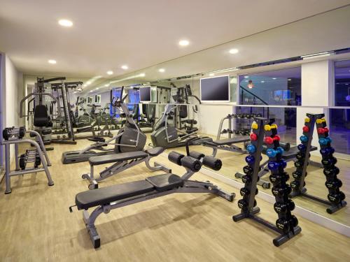 a gym with several tread machines in a room at Bellazure Hotel in Akyarlar