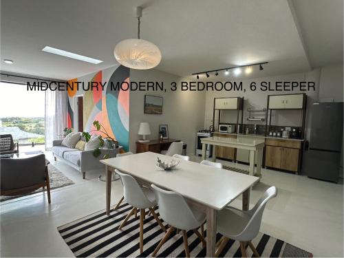 a kitchen and living room with a white table and chairs at Constantia View Apartments- Luxury Self Catering in Cape Town