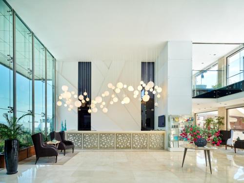 a lobby with chairs and a table and chandeliers at Bellazure Hotel in Akyarlar