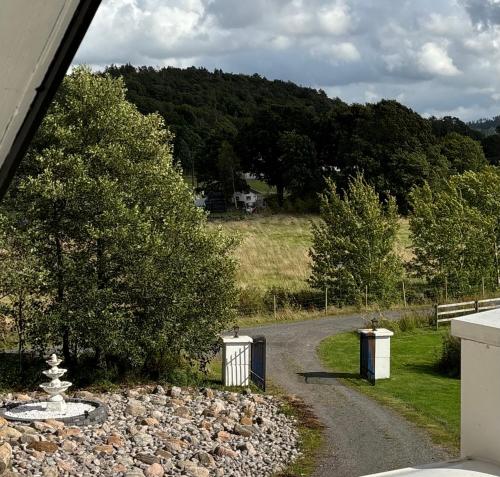 a gravel road with two trash cans on the side at Annas gård, stall & pensionat in Fjärås
