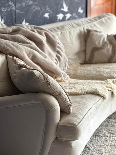 a couch with a blanket on top of it at Annas gård, stall & pensionat in Fjärås