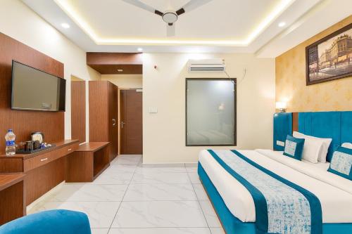 a hotel room with a bed and a tv at Hotel Pawan Regency- Best Mountain View Hotel In McLeodganj in McLeod Ganj