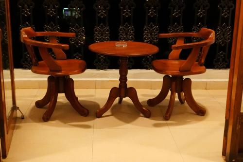 two chairs and a wooden table and a table and chairs at Broad Bean Royal Resort Goa in Canacona