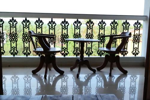 three chairs in front of a wrought iron fence at Broad Bean Royal Resort Goa in Canacona