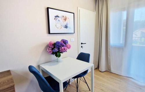 a white table with a vase of flowers on it at Studio Apartment Jasna 1 by Villas Guide in Rovinj