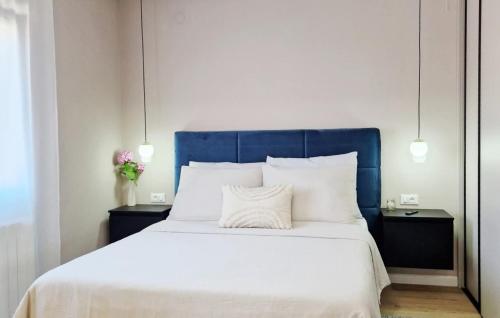 a bed with a blue headboard and white sheets and pillows at Studio Apartment Jasna 1 by Villas Guide in Rovinj