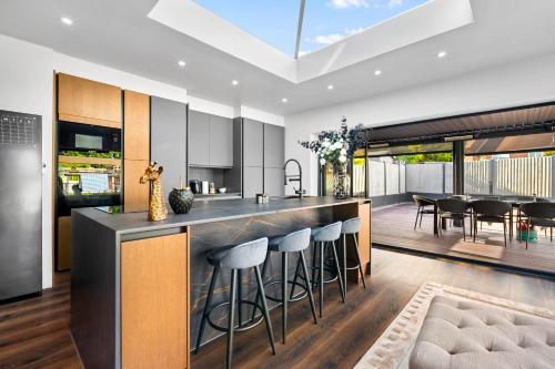 an open kitchen with a bar with stools at Superb Luxury 3 Bedroom House - Garden - Parking - Outdoor Playground 17P in Birmingham