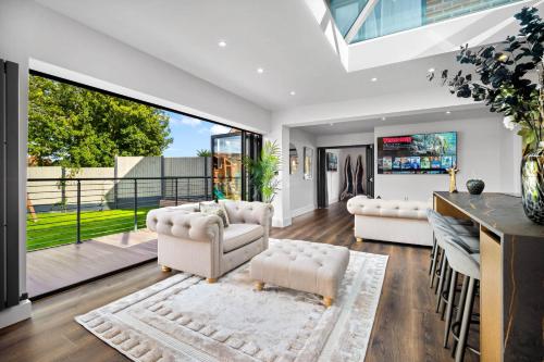 a living room with white furniture and a large window at Superb Luxury 3 Bedroom House - Garden - Parking - Outdoor Playground 17P in Birmingham