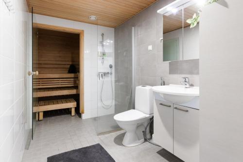 a bathroom with a toilet and a sink and a shower at Cosy family apartment with parking, sauna and balcony in Jyväskylä
