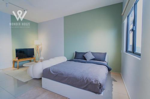 a white bedroom with a bed and a tv at Modern Stay at Seri Kembangan - 20 mins to Pavilion Bukit Jalil in Seri Kembangan