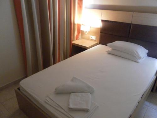 a white bed with two towels on top of it at Esperia in Thessaloniki