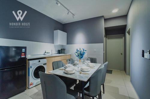 a kitchen and dining room with a table and chairs at Modern Stay at Seri Kembangan - 20 mins to Pavilion Bukit Jalil in Seri Kembangan