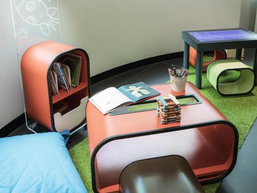 a room with a bed and a table with a suitcase at Novotel Melbourne On Collins in Melbourne
