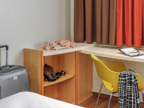 a room with a bed and a desk and a chair at ibis Hotel Frankfurt Messe West in Frankfurt