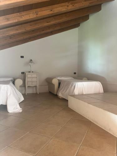 two beds in a room with a tiled floor at Hotel Villa Costanza in Pontenure