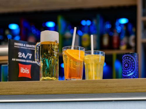 three glasses of beer sitting on a bar at ibis Hotel Frankfurt Messe West in Frankfurt