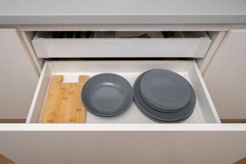 two plates and pans sitting in a drawer at Cozy Dzintaru apartment - Steps from Forest and Sea in Jūrmala