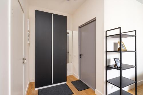 a room with a black closet and a door at Cozy Dzintaru apartment - Steps from Forest and Sea in Jūrmala