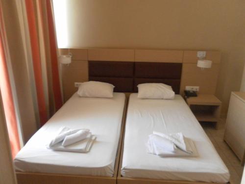 two beds in a room with white towels on them at Esperia in Thessaloniki