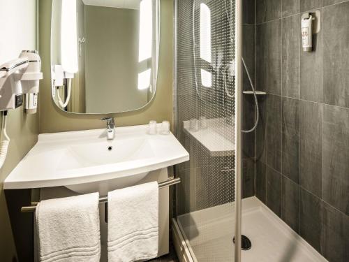a bathroom with a sink and a shower at Hotel ibis Faro Algarve in Faro