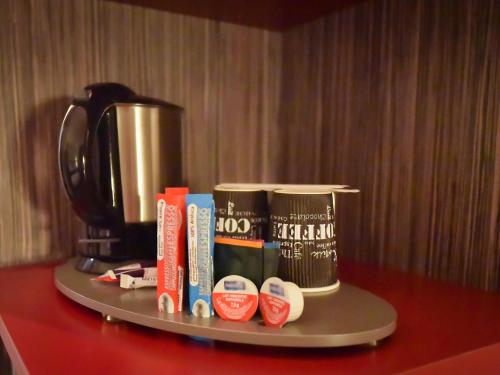 a tray with a coffee pot and books on a table at Hotel Mercure Blois Centre in Blois