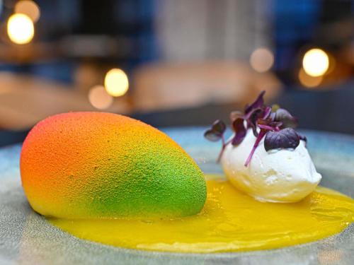 a plate with a fruit and ice cream on it at Hotel Mercure Blois Centre in Blois