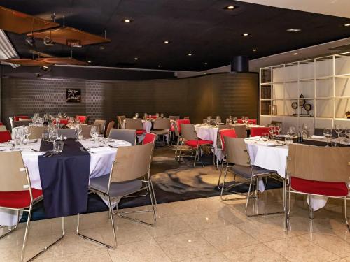 a dining room with tables and chairs and tablesktop at Hotel Mercure Blois Centre in Blois
