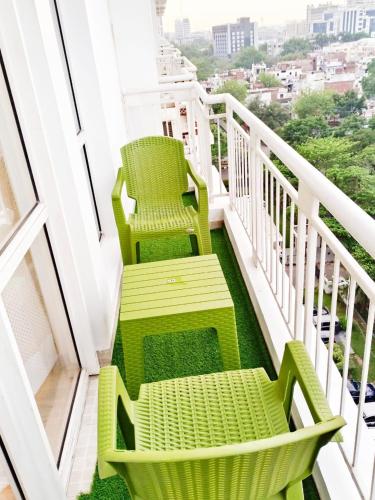 ラクナウにあるLucknow express by origin Suites DLF MY PAD near Gomti Nagar Railway Station Lucknowのバルコニー(緑の椅子2脚付)