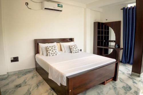 a bedroom with a large bed with white sheets and pillows at Ominiyet Villa in Galle