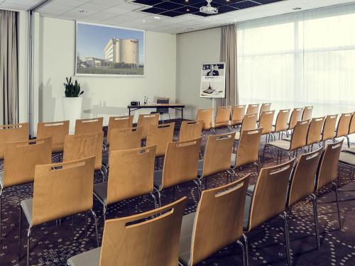 a room with rows of chairs and a table at Mercure Compiègne Sud in Compiègne