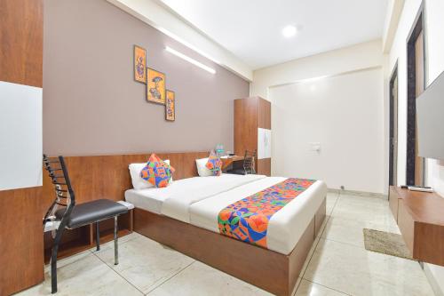 a bedroom with a bed and a chair in it at FabExpress Fusion Stays in Indore