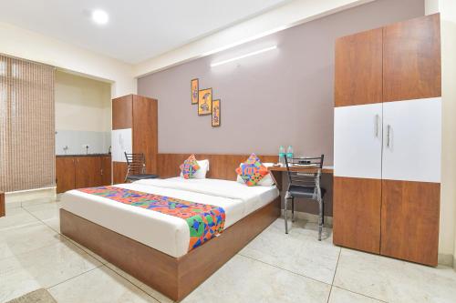a bedroom with a bed and a table and chairs at FabExpress Fusion Stays in Indore