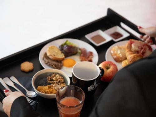 a table with a tray of breakfast foods and drinks at Hôtel Mercure Lyon Centre Charpennes Parc de la Tête d'Or in Villeurbanne