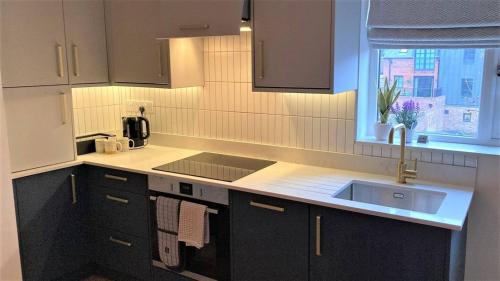 a kitchen with black cabinets and a sink and a window at Escape 2 Unwind, Minster Retreat - Sleeps 5 in York