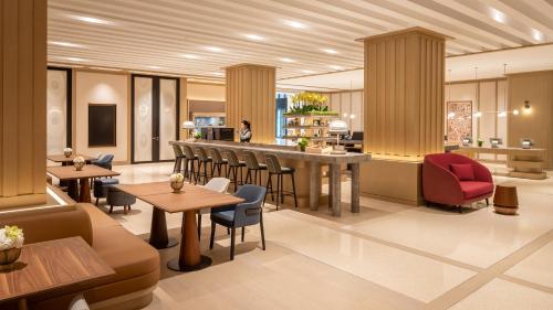 a restaurant with tables and chairs and a bar at Traders Hongqiao Airport,Shanghai in Shanghai
