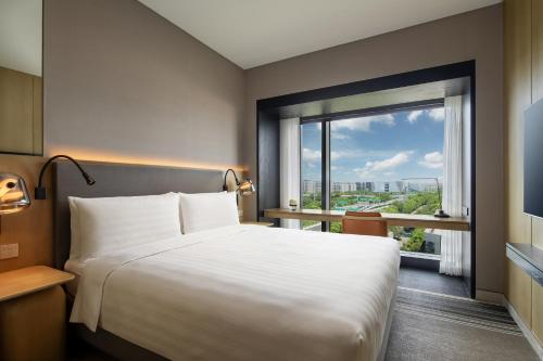 a bedroom with a large bed and a large window at Traders Hongqiao Airport,Shanghai in Shanghai