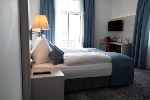 a bedroom with a large bed with a window at Hotel Restaurant Bellevue au Lac in Thun