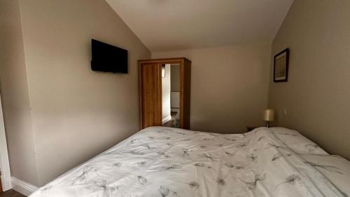 a bedroom with a large bed with white sheets at Entick Lodge No 4 in Dunswell