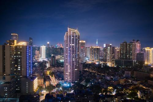 eine Skyline der Stadt in der Nacht mit einem hohen Gebäude in der Unterkunft Lavande Hotel Guangzhou Beijing Road Pedestrian Street Haizhu Square Metro Station Branch - Free Deliver Service to Canton Fair Complex During Canton Fair Period in Guangzhou