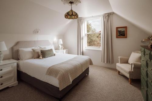 una camera da letto con un letto, una sedia e una finestra di The Balfour, classic cottage in Launceston's Café Quarter a Launceston