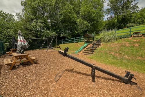 a park with a playground with a slide and a swing at The Shakespeare Inn in Coalport