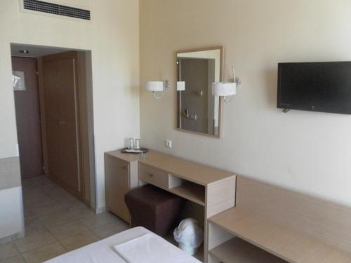 a hotel room with a desk and a tv on the wall at Esperia in Thessaloniki