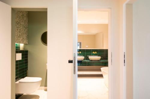 ein Badezimmer mit zwei Waschbecken und zwei Toiletten in der Unterkunft Van der Valk Naturresort Drewitz in Nossentiner Hütte