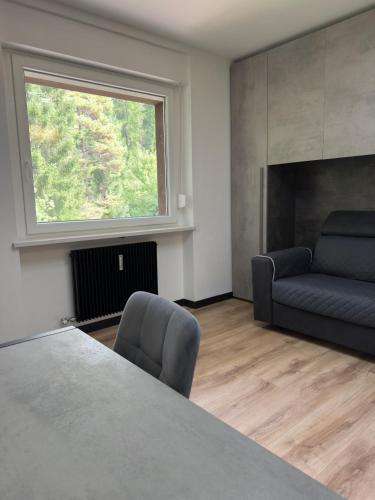 a living room with a table and a couch at Regina del bosco in Ronzone