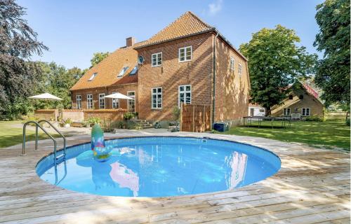 a swimming pool in front of a house at Large Holiday Home With Pool On South Lolland Coast in Dannemare