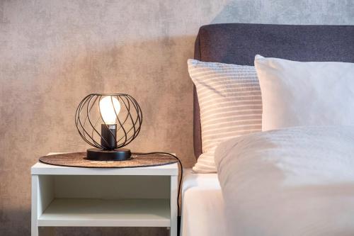 eine Lampe auf einem Nachttisch neben einem Bett in der Unterkunft Ferienwohnung Morgensonne in Schönwald