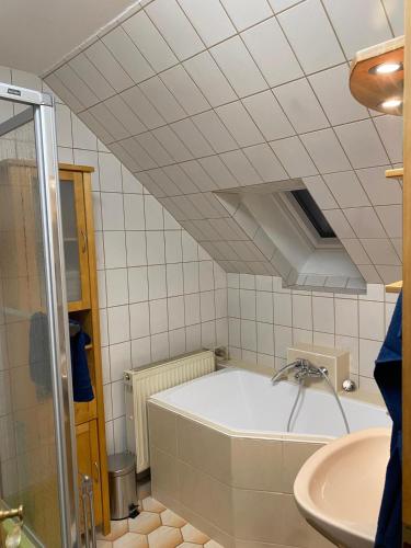 a bathroom with a bath tub and a sink at 1 bedroom with private bathroom & Kitchenette in Oberthulba