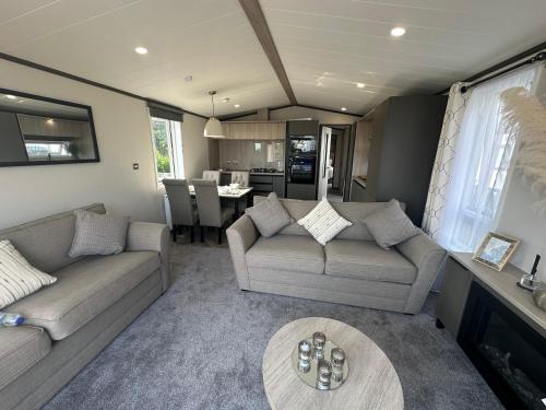 a living room with two couches and a table at 7b Oakwood village in Wilberfoss
