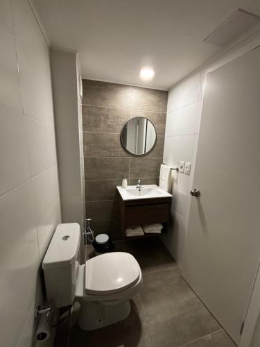ein Badezimmer mit weißer Toilette und Waschbecken in der Unterkunft A Pasos Tres Cruces in Montevideo